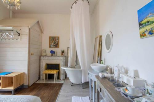 a bathroom with two sinks and a tub and a fireplace at Villa de charme, 15 personnes, vue canal in Rohan