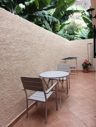 a table and chairs sitting next to a wall at Maresia's House in Madalena do Mar