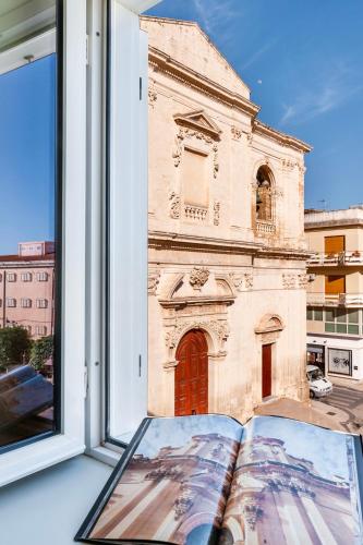 a book sitting on a window sill with a church at Casa San Lio in Noto