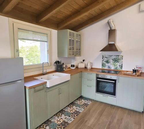 een keuken met witte kasten, een gootsteen en een raam bij Pontile 1 in Paratico