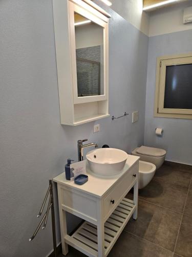 a bathroom with a sink and a toilet and a mirror at Pontile 1 in Paratico