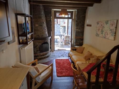 a living room with a couch and a fireplace at Villa Aretousa in Palaios Agios Athanasios