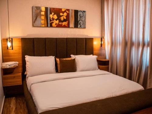 a bedroom with a large bed with white sheets at 2 - 4 bedroom apartments in Eko Atlantic City in Lagos