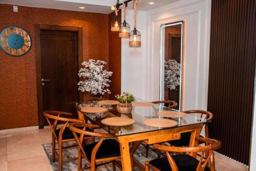 a dining room with a table and chairs and a clock at 2 - 4 bedroom apartments in Eko Atlantic City in Lagos