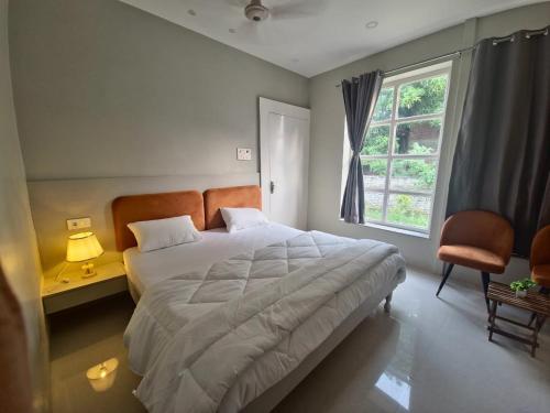 Niwaas Stay في فاراناسي: غرفة نوم بسرير كبير ونافذة