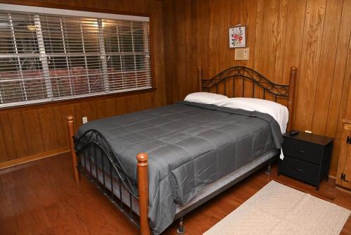 a bedroom with a bed in a room with wooden walls at Mid-City Rustic Retreat in Baton Rouge