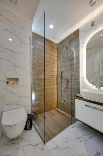 a bathroom with a shower and a toilet and a sink at Luxor Collection Apartments in Tbilisi City