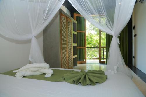 a bedroom with a bed with towels on it at Mindara Villa in Galle