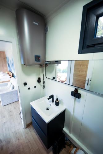 a bathroom with a sink and a mirror at ermiglamping in Jince