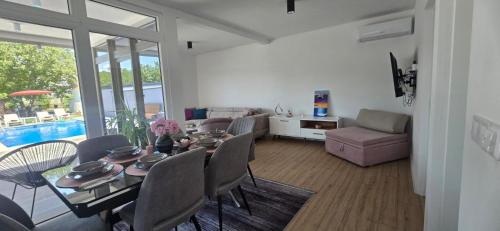 Una sala de estar con una mesa y sillas y un sofá. en Vila Ayla, en Blagaj
