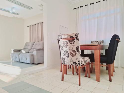 a living room with a table and a chair at Casa 4 quartos no centro da cidade - 3 vagas de garagem in Campo Grande