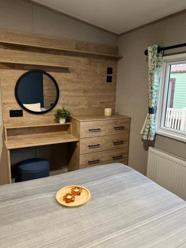 a bedroom with a bed with a mirror and a table at Modern Caravan 2025 with Decking in Morecambe