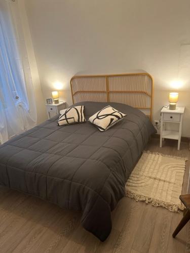 een slaapkamer met een groot bed met twee kussens erop bij Les mirabelliers 