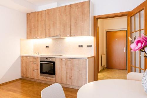 a kitchen with wooden cabinets and a stove top oven at Apartmán IRIS Poděbrady 2 in Nymburk