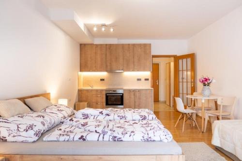 a bedroom with a large bed and a kitchen at Apartmán IRIS Poděbrady 2 in Nymburk