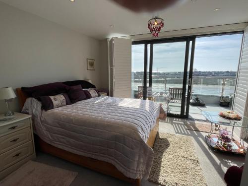 a bedroom with a large bed and a large window at Special Occasion, Stunning sea view balconied Penthouse suite in Shoreham-by-Sea