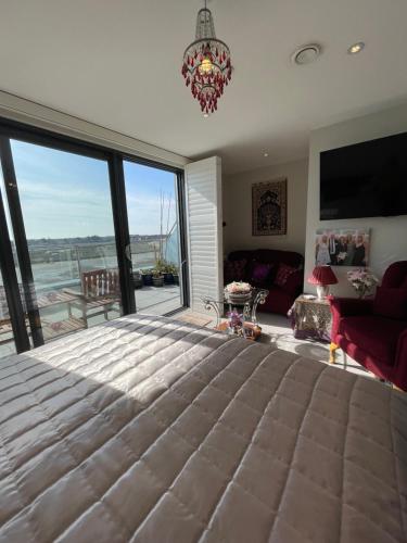 a bedroom with a large bed with a large window at Special Occasion, Stunning sea view balconied suite in Shoreham-by-Sea