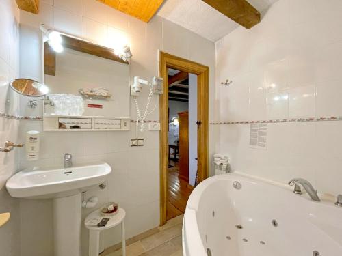 a bathroom with a bath tub and a sink at Hotel Peruskenea in Jaunsaras