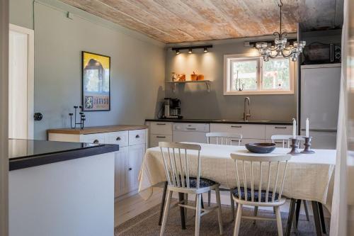 a kitchen with a table and chairs in a kitchen at Annexet Orrabackens in Järvsö