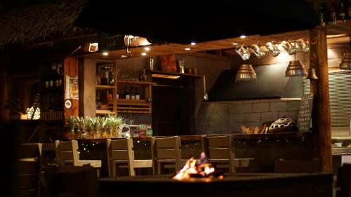 a restaurant with a fire in the middle of a bar at La Bicok EcoLodge in Mindo