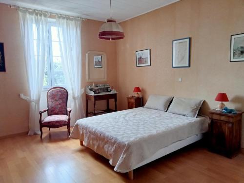 une chambre avec un lit, une chaise et un bureau dans l'établissement les Micocouliers, à La Celle-sous-Gouzon