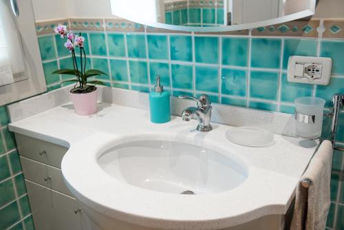 a bathroom with a sink and a blue tiled wall at Rosa del Grappa in Rosà