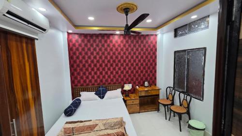 a bedroom with a bed and a red wall at Meera Hotel And Lodging in Badarpur
