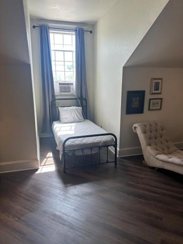 a bedroom with a bed and a window with blue curtains at Innkeeper Suite at The Currier Inn in Greeley