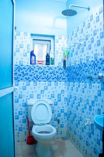 a blue and white bathroom with a toilet and a sink at Zana homes in Kilifi