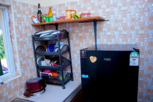 una nevera negra en una cocina con estantería en Zana homes, en Kilifi