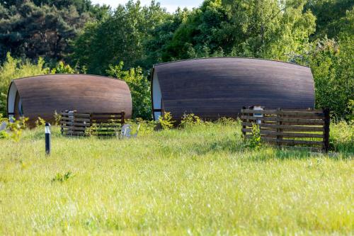 two circular wooden structures in a field of grass at Sage- Glamping Pod in Malahide