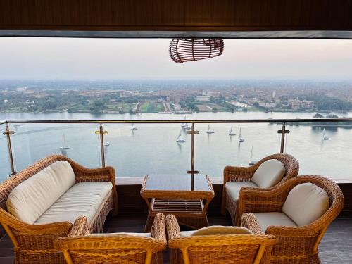 a balcony with chairs and a table and a view of the water at Lumen Residence in Cairo