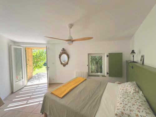 a bedroom with a bed and a ceiling fan at Maison en pierre rénovée avec jardin et piscine privative chauffée in Hyères