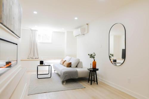 uma sala de estar branca com uma cama e um espelho em The Ember Suite em Peterborough