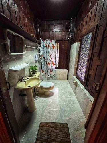 a bathroom with a sink and a toilet at Thai Classic House Rimtalay in Ban Rong Po