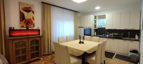 Una cocina y un comedor con mesa y chimenea. en Dušanovac, en Raška