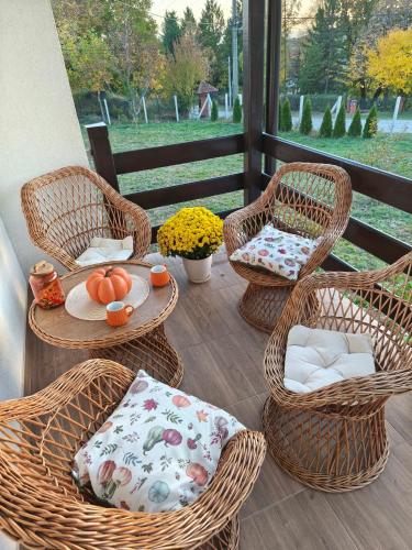a patio with wicker chairs and a table with pumpkins at Košutica Vila in Koraćica
