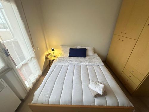 a small bedroom with a white bed with a blue pillow at Tra Cielo e Mare da Vale in Fano