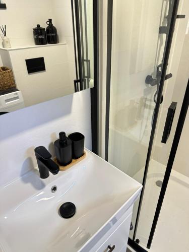 a bathroom with a white sink and a shower at Domek Sosna 