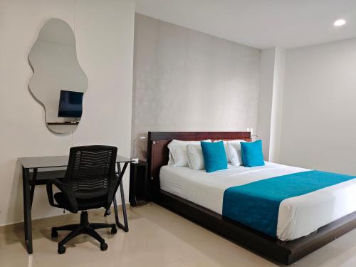 une chambre avec un lit, un bureau et une chaise dans l'établissement Edificio Morros Vitri, à Carthagène des Indes