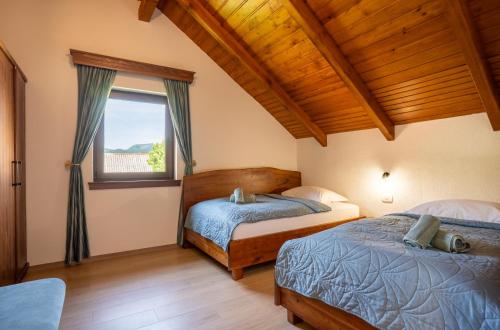 een slaapkamer met twee bedden en een raam bij Villa D-IKA in Brušane