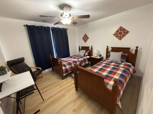 Entire Cozy Apartment Fully Renovated Modern Style في نورث برونزويك: غرفة نوم بها سريرين ومروحة سقف