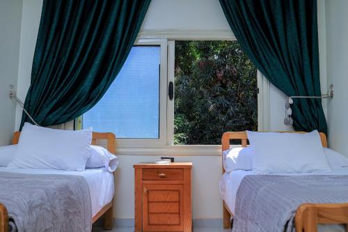a bedroom with two beds and a window at Mayor Nubian guest house in Aswan