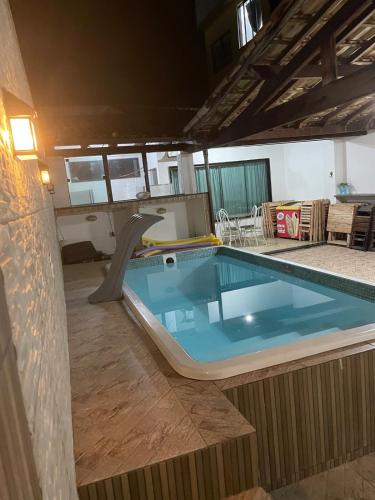 ein großer Swimmingpool mit Rutsche in einem Haus in der Unterkunft Hostel and Party Space! in Três Rios