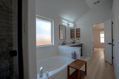 a white bathroom with a large tub and a window at Modern 4BR w Natural Light, High Ceilings in Roanoke