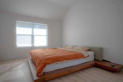 a bed in a white room with a window at Modern 4BR w Natural Light, High Ceilings in Roanoke