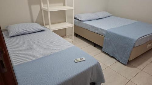 two twin beds in a room with a scale at bairro Oliveira - casa 3 quartos com ar in Campo Grande