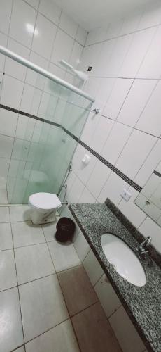 a bathroom with two sinks and a toilet at bairro Oliveira - casa 3 quartos com ar in Campo Grande