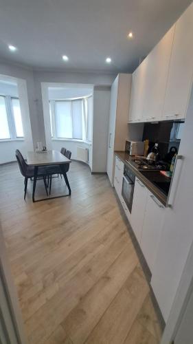 Una cocina con una mesa y un comedor. en Odyssey, en Chişinău