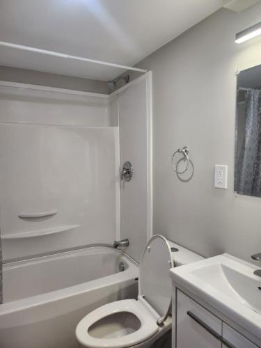 a white bathroom with a toilet and a sink at Elegance Lounge in Winnipeg